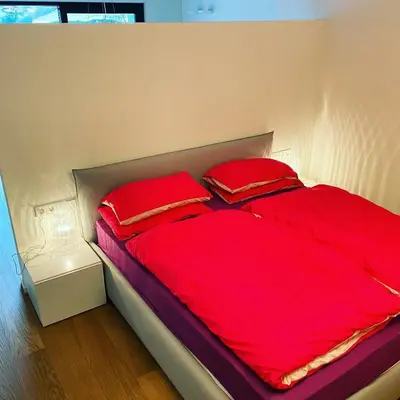 a bedroom with a bed with a red blanket at Casa Sciliar centro paese PINK in Fiè