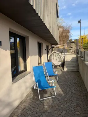 a patio with tables and chairs and a building at Casa Sciliar centro paese PINK in Fiè