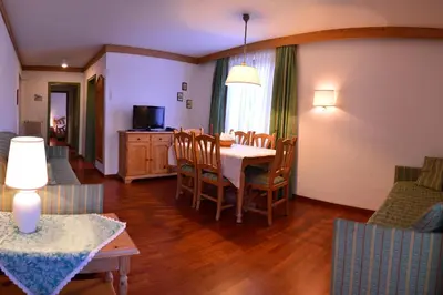 a living room with a dining room table and chairs at Appartamenti Astoria La Villa in La Villa