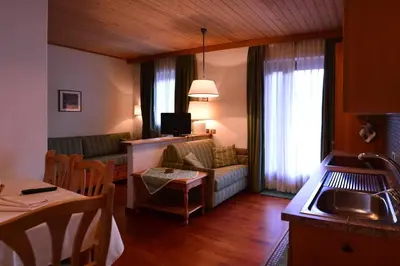 a kitchen and living room with a couch and a table at Appartamenti Astoria La Villa in La Villa