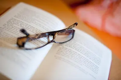 a pair of glasses sitting on top of an open book at Villa Trogerhof in Ora/Auer