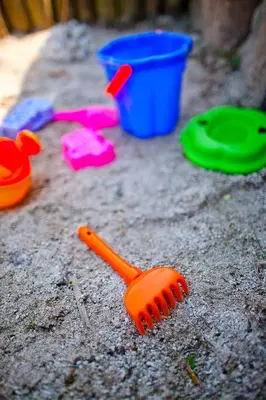 an orange plastic fork sitting on the ground with other toys at Villa Trogerhof in Ora/Auer