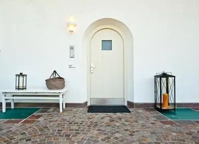 a white hallway with a white door and a bench at Villa Trogerhof in Ora/Auer