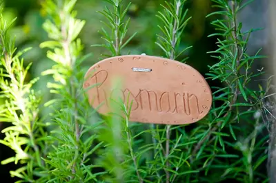 a metal object that says garden in the bushes at Ferienwohnungen Trogerhof in Ora/Auer