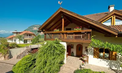 a house with a deck and a balcony at Ferienwohnungen Trogerhof in Ora/Auer