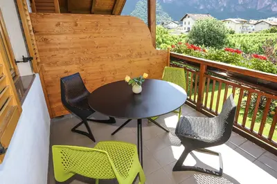 a patio with a table and chairs on a balcony at Ferienwohnungen Trogerhof in Ora/Auer