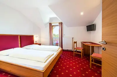 a hotel room with a bed and a desk at Pension Stamserhof in Nalles