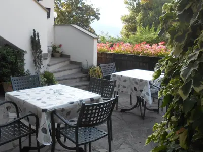 a patio with two tables and chairs and flowers at Pension Stamserhof in Nalles
