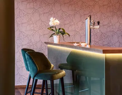 a bar with two chairs and a counter with a mirror at Marini's giardino Hotel in Tirolo