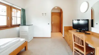 a bedroom with a bed and a television on a desk at Hotel Corno Bianco in Nova Ponente