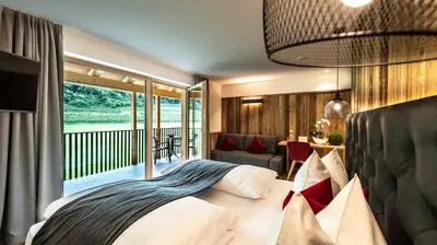 a bedroom with a bed and a balcony at Zum Alten Moar in Bressanone