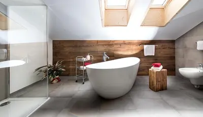a bathroom with a large white tub and a sink at Zum Alten Moar in Bressanone