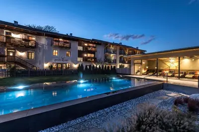a hotel with a swimming pool in front of a building at Zum Alten Moar in Bressanone