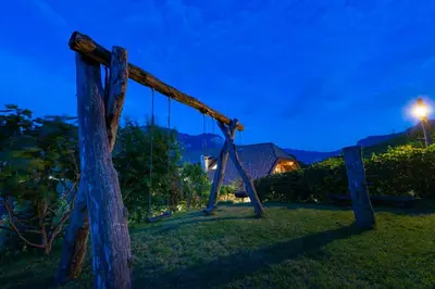 an empty swing in a field at night at Finkenhof: Ferienwohungen - Urlaub auf dem Bauernhof in Termeno