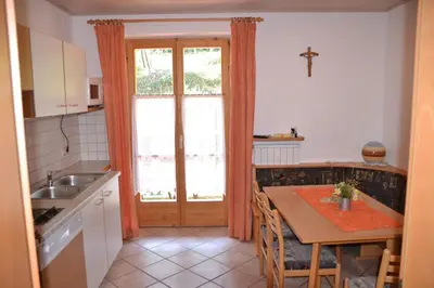 a kitchen with a table and a kitchen with a window at Finkenhof: Ferienwohungen - Urlaub auf dem Bauernhof in Termeno