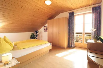 a bedroom with a large bed with a yellow blanket at Finkenhof: Ferienwohungen - Urlaub auf dem Bauernhof in Termeno