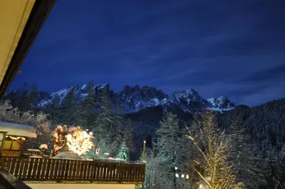 a view of the mountains from a balcony at night at Haus Christian in Nova Levante