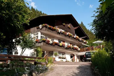 a white building with flowers on the balcony at Haus Christian in Nova Levante