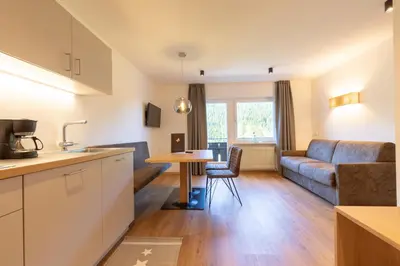 a kitchen and living room with a couch and a table at Haus Christian in Nova Levante
