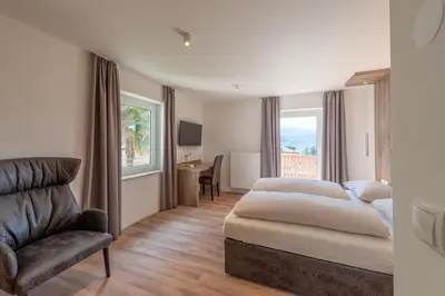 a bedroom with a bed and a chair and a desk at Beim Sarner in Caldaro