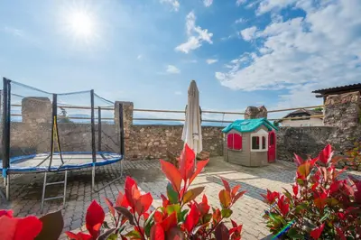 a view of a patio with an umbrella and a house at Beim Sarner in Caldaro