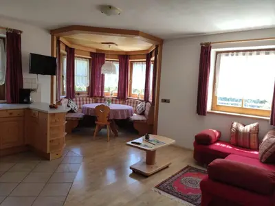 a living room with a red couch and a table at Obkirchhof in Unsere Liebe Frau im Walde