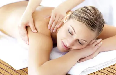 a woman laying on a towel in a massage at Castel Maurn Dolomites in San Lorenzo di Sebato