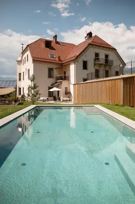 a large swimming pool in front of a house at Castel Maurn Dolomites in San Lorenzo di Sebato
