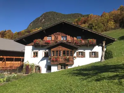 a white house with a balcony on a hill at Campedèl Hof in Castelrotto