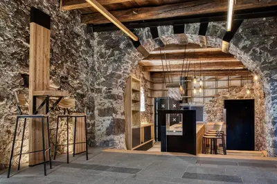 a room with a stone wall and wooden beams at Campedèl Hof in Castelrotto