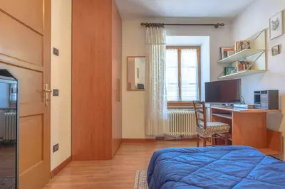 a bedroom with a bed and a desk with a computer at Appartamento Da Vittoria Valda Val di Cembra in Valda