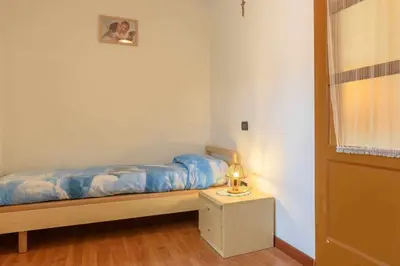 a bedroom with a bed and a lamp on a table at Appartamento Da Vittoria Valda Val di Cembra in Valda