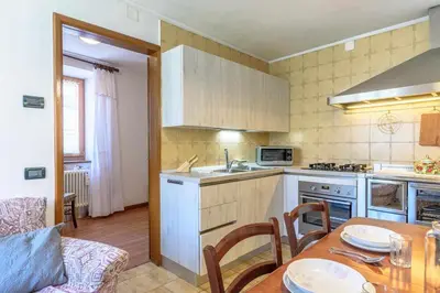 a kitchen with a wooden table and a kitchen with a dining room at Appartamento Da Vittoria Valda Val di Cembra in Valda