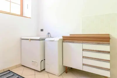a bathroom with a sink and a washing machine at Appartamento Da Vittoria Valda Val di Cembra in Valda
