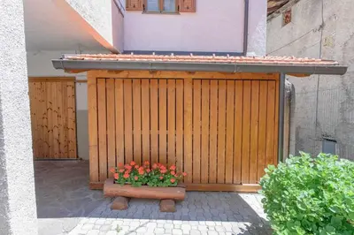 a wooden gate with a pot of flowers on a patio at Appartamento Da Vittoria Valda Val di Cembra in Valda