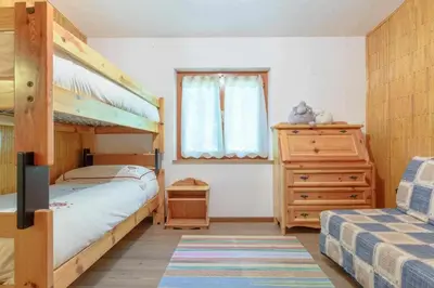 a bedroom with a bunk bed and a dresser at Al Faggio Ponciach Altavalle OSPITAR in Sover