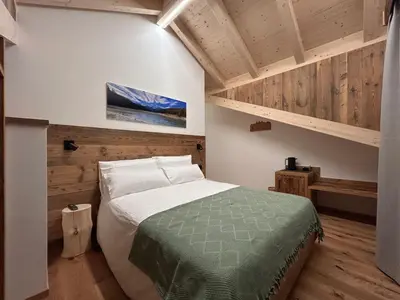 a bedroom with a bed and a wooden ceiling at Agritur Bella di Bosco in Coredo