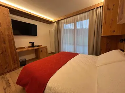a bedroom with a bed and a large window at Agritur Bella di Bosco in Coredo