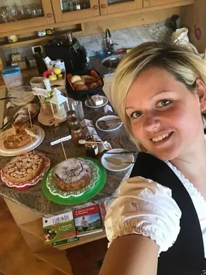 a woman standing in front of a table of food at Agritur Bella di Bosco in Coredo