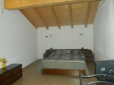 a bedroom with a bed and a wooden ceiling at Agritur Vista Lago in Revò