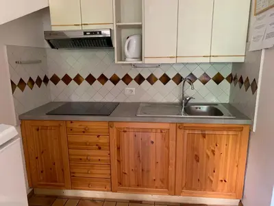 a kitchen with wooden cabinets and a sink at Residence Trunka Lunka in Cavalese