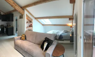 a living room with a couch and a bedroom at The Bijoux - Dolomites in Agordo