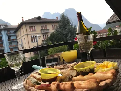a table with a bottle of wine and a plate of food at The Bijoux - Dolomites in Agordo