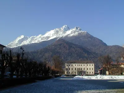 a snow covered mountain with a building in front of it at The Bijoux - Dolomites in Agordo