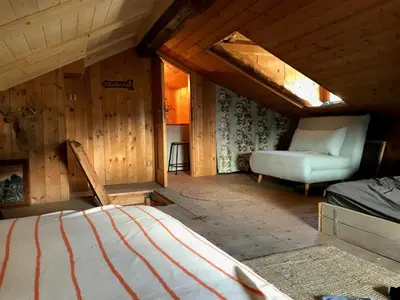 a bedroom with a bed and a chair in a attic at Cherz Romantic House in Arabba
