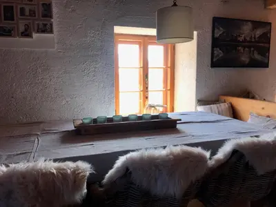 a dining room table with two furry chairs and a window at Cherz Romantic House in Arabba