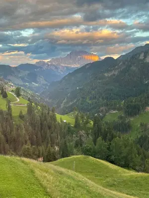 a grassy hill with a view of a mountain at Cherz Romantic House in Arabba