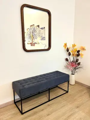 a black bench sitting in front of a mirror at My Dolomites Home in Livinallongo del Col di Lana