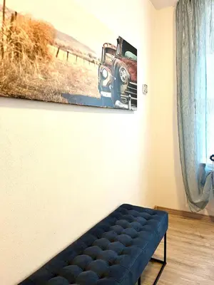 a couch in a room with a picture of a truck on the wall at My Dolomites Home in Livinallongo del Col di Lana