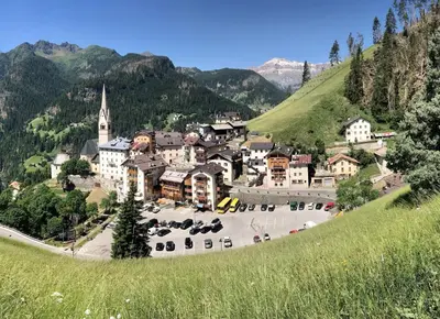 a small town on a hill with a church at My Dolomites Home in Livinallongo del Col di Lana